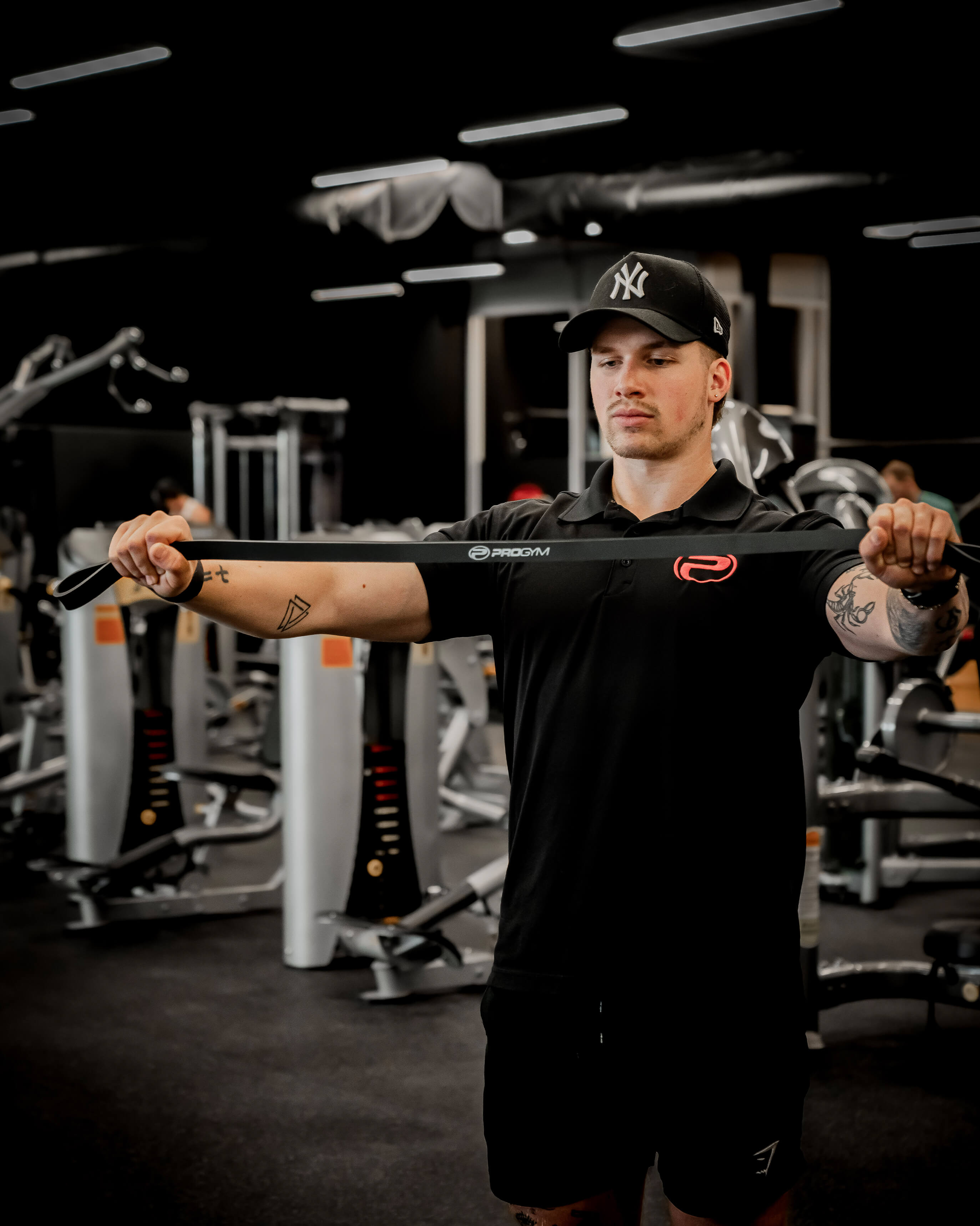 Entraîneur ProGym effectuant un exercice avec une bande de résistance noire