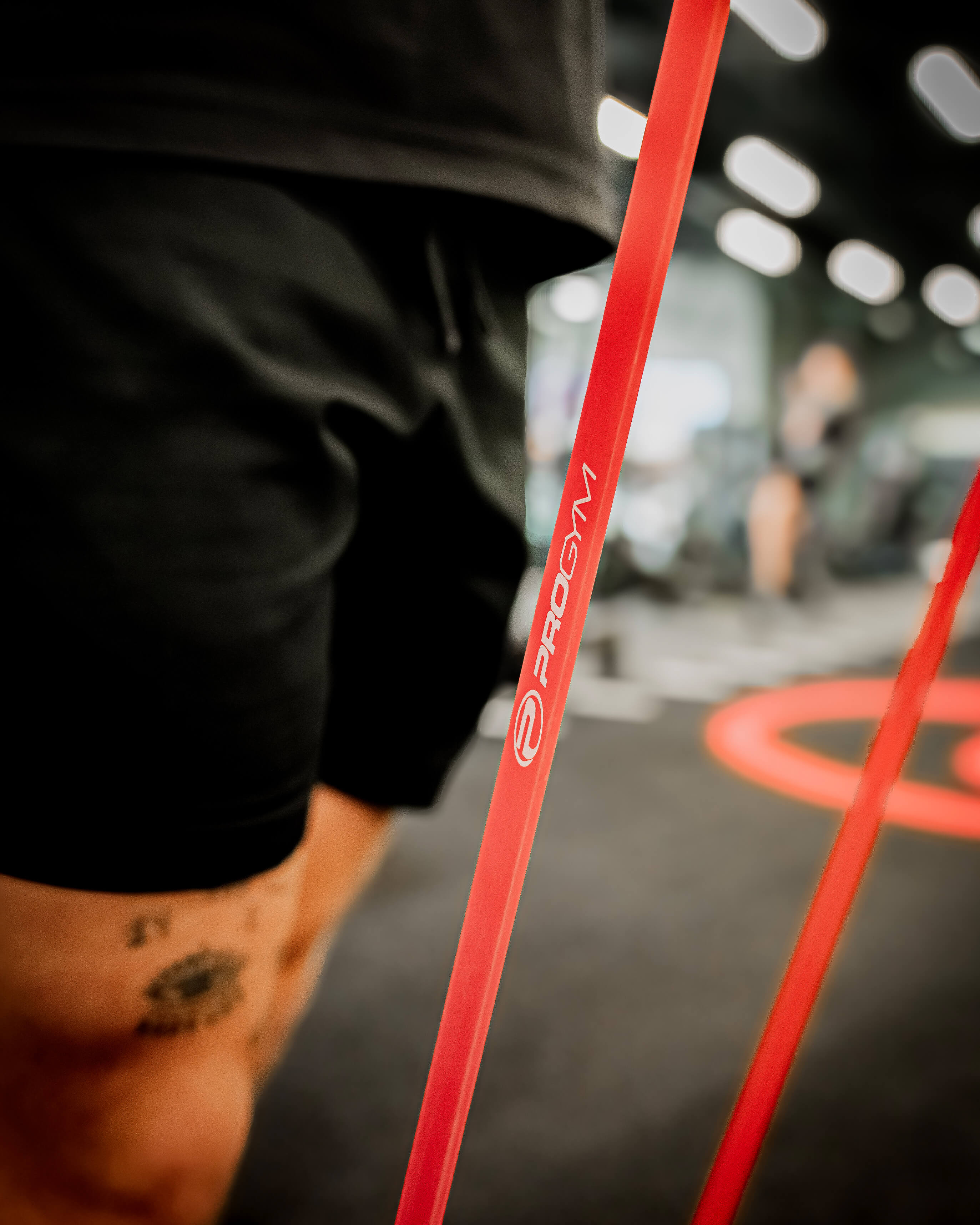 Gros plan sur une bande de résistance rouge ProGym tenue par une personne