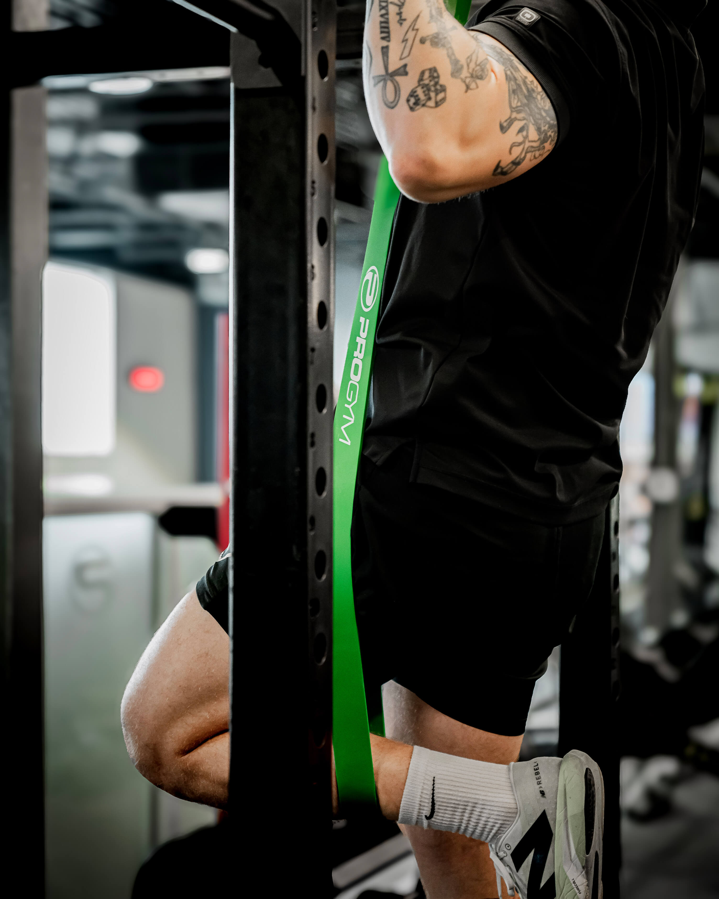 Athlète utilisant une bande de résistance verte ProGym pour un exercice de traction assistée