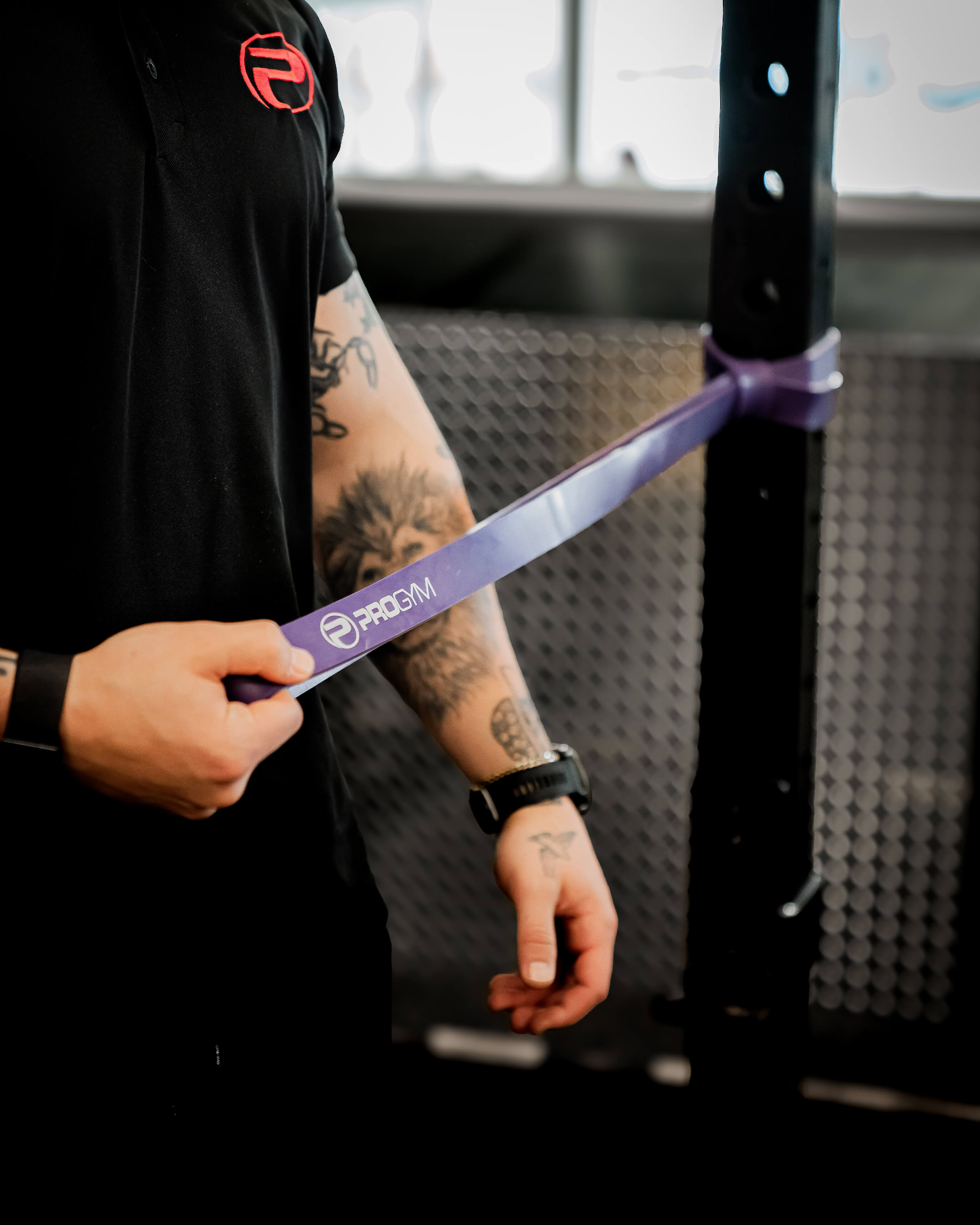 Athlète utilisant une bande de résistance violette ProGym attachée à une station de musculation