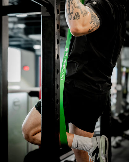 Athlète utilisant une bande de résistance verte ProGym pour un exercice de traction assistée